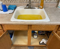 Clogged bathroom sink with a clog and yellow water.
