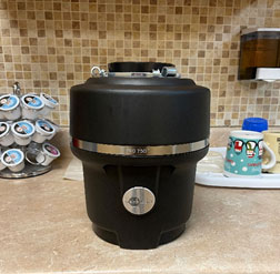 Photo of new black garbage disposal on kitchen counter