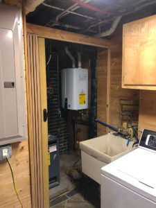tankless water heater in ne minneapolis basement attached to wooden wall