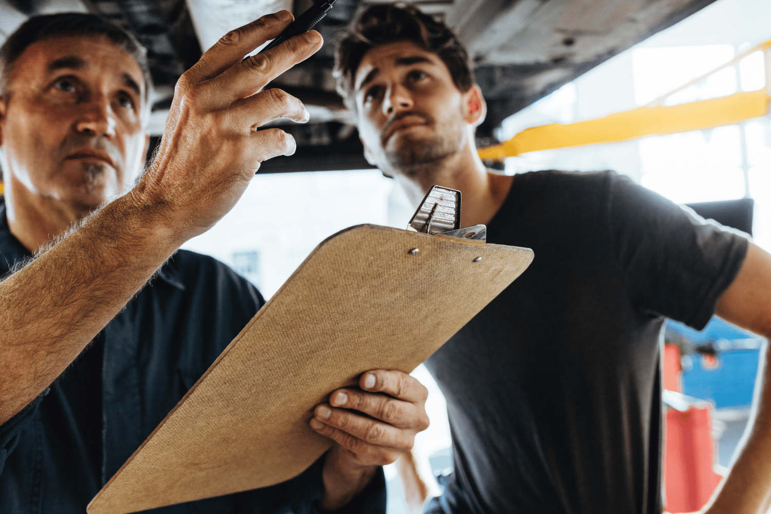 Plumber inspecting plumbing with homeowner