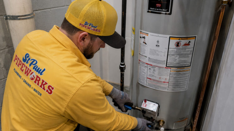 St. Paul plumber inspecting a residential water heater that is not producing hot water, representing common water heater troubleshooting for homeowners in the Minneapolis–St. Paul metro area.