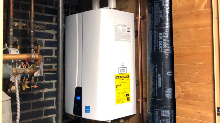 A wall-mounted Energy Star tankless water heater installed in a home basement, highlighting key tankless water heater benefits in St. Paul.