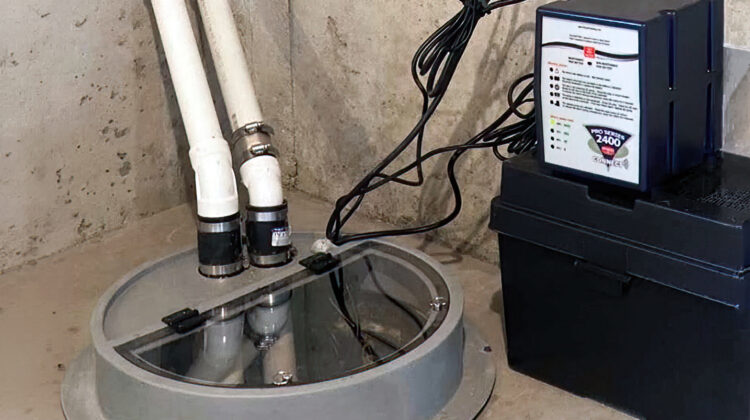 Sump pump in a basement pit with battery backup, helping protect a St. Paul home from storm-related flooding.
