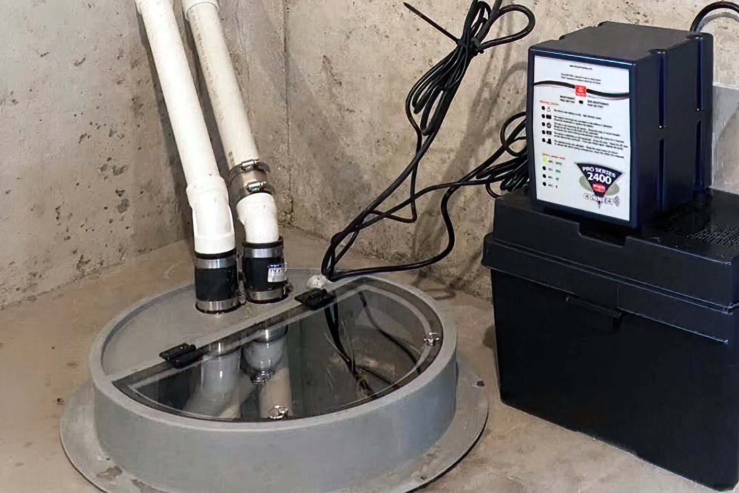 Sump pump in a basement pit with battery backup, helping protect a St. Paul home from storm-related flooding.